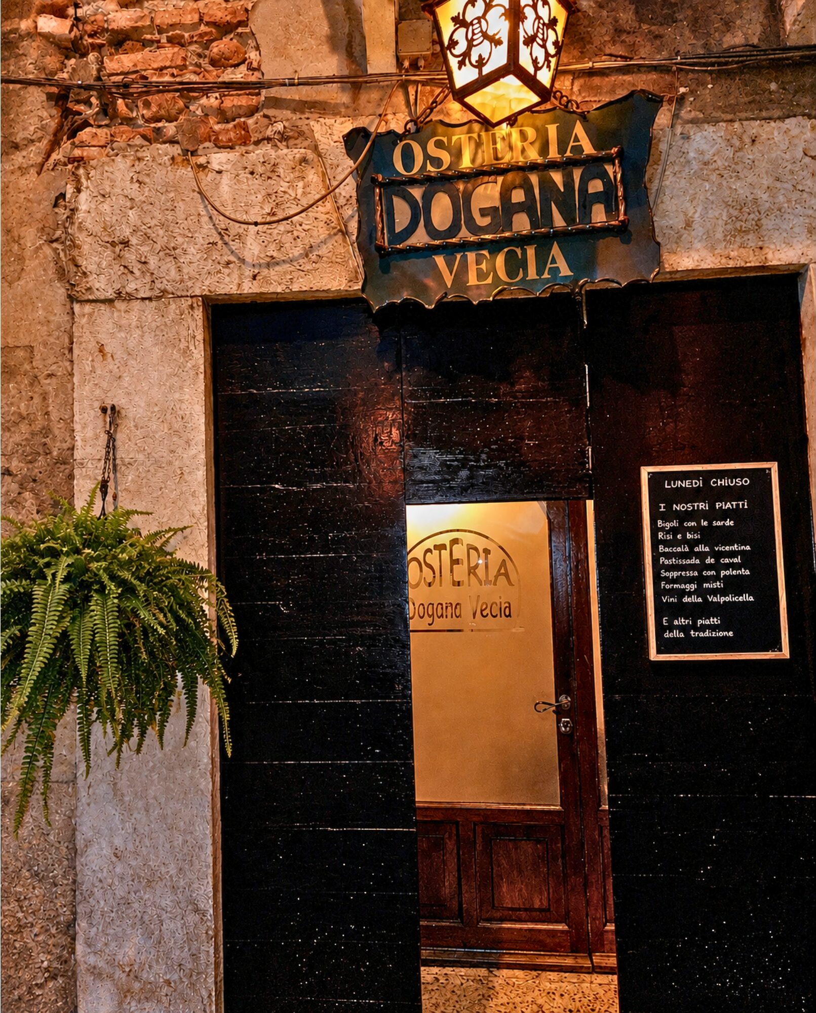 Interno dell'osteria con tavoli, vino e formaggi